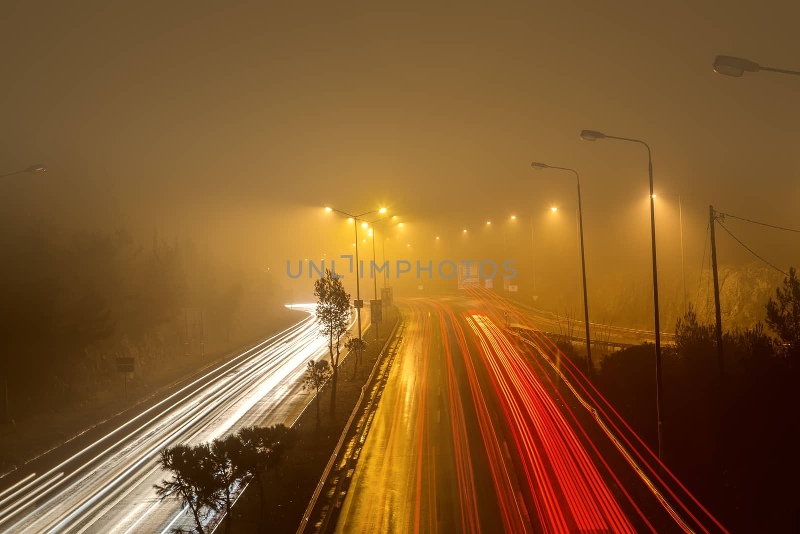 Speed Traffic - light trails on motorway highway at night with fog, long exposure abstract urban background