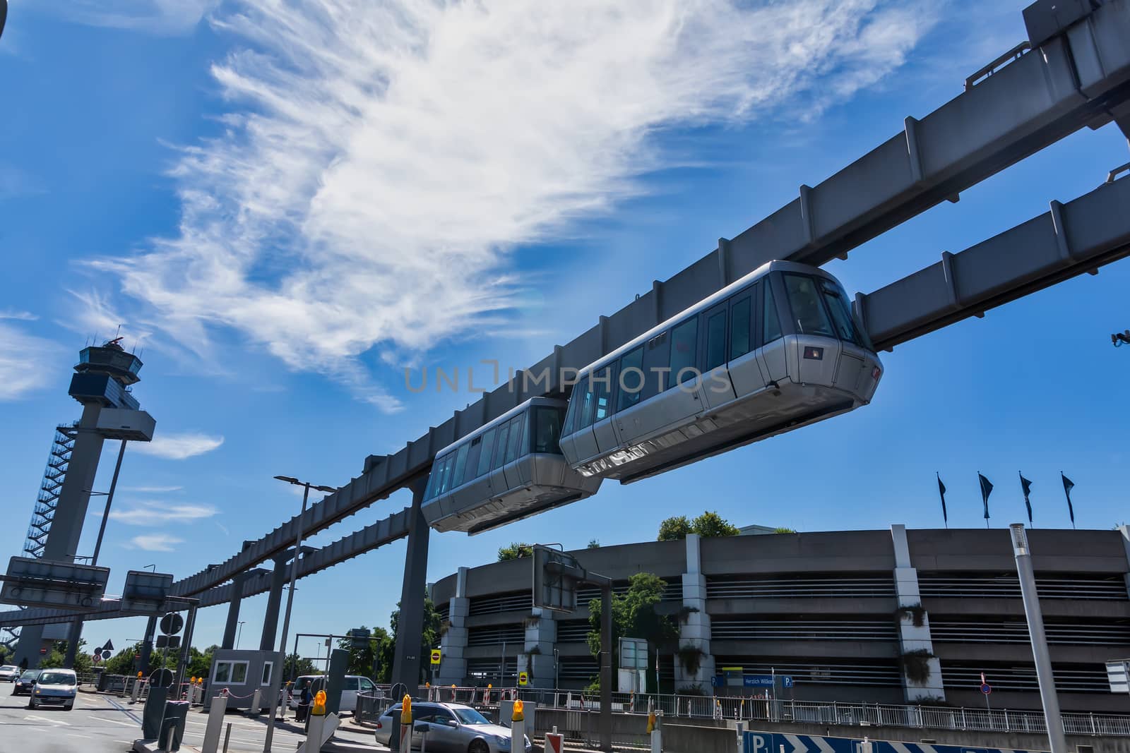 Dusseldorf, Germany - July 3, 2018: Public transportation system Sky-Train hanging from elevated guideway beam on columns in Dusseldorf, Germany. The SkyTrain, takes passengers to the airport terminal