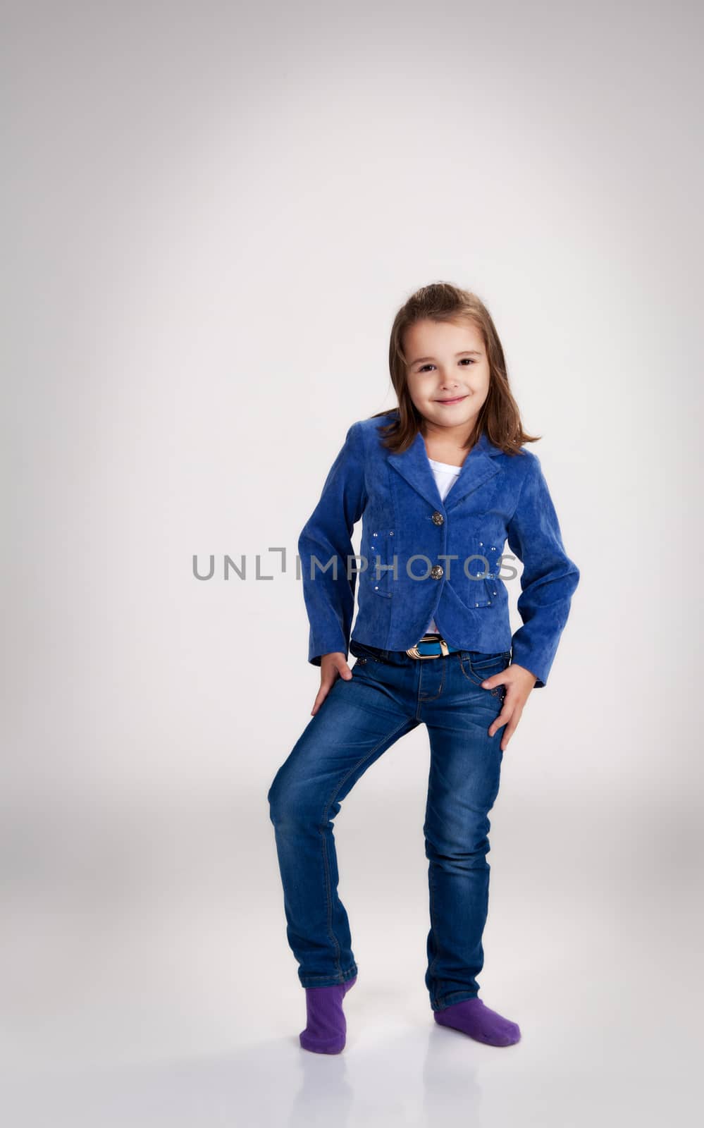 little girl in blue jeans and jacket posing in the studio by raddnatt