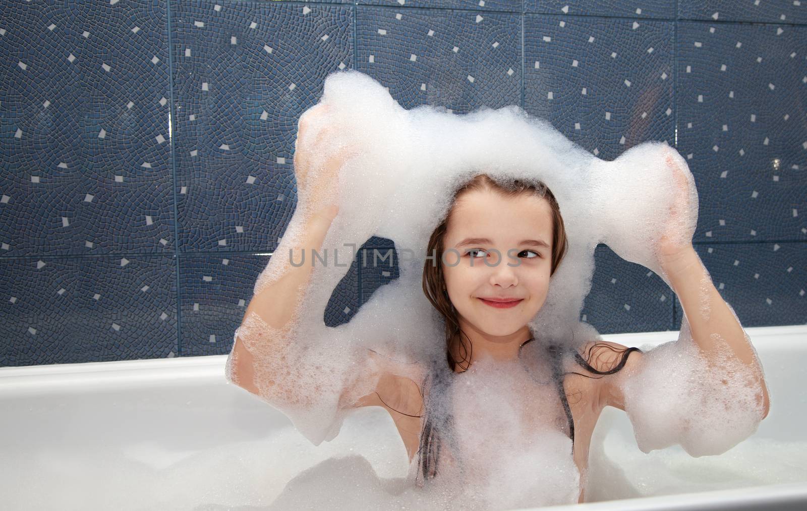 little girl sitting in a bath and imposes soap suds on her head by raddnatt