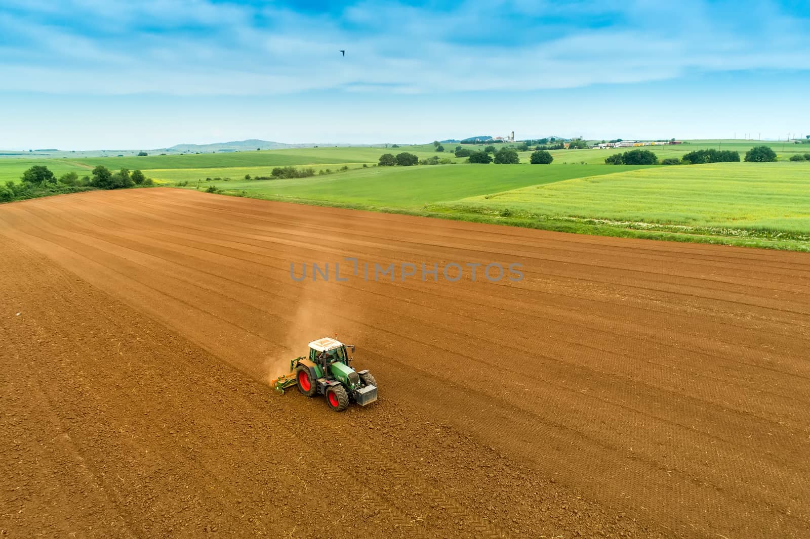 Aerial shot of  Farmer with a tractor on the agricultural field  by ververidis