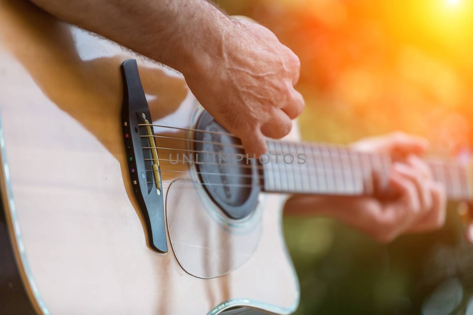 Male hand playing on acoustic guitar by ververidis