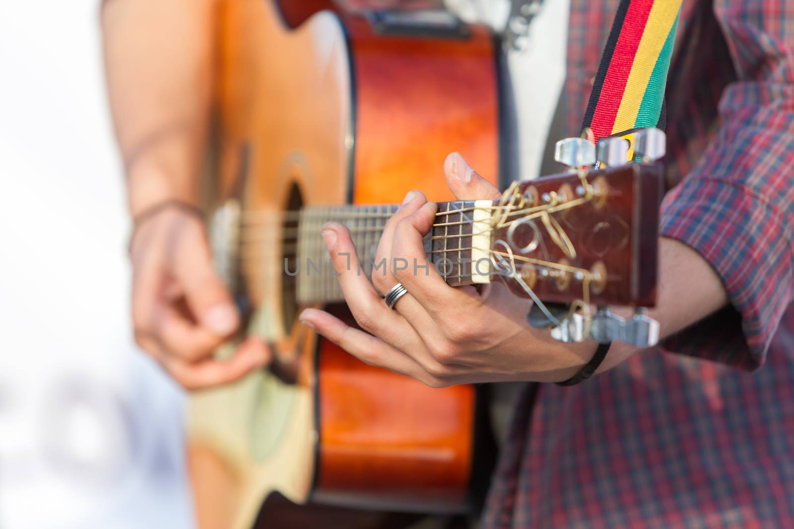 man playing acoustic guitar with nature light