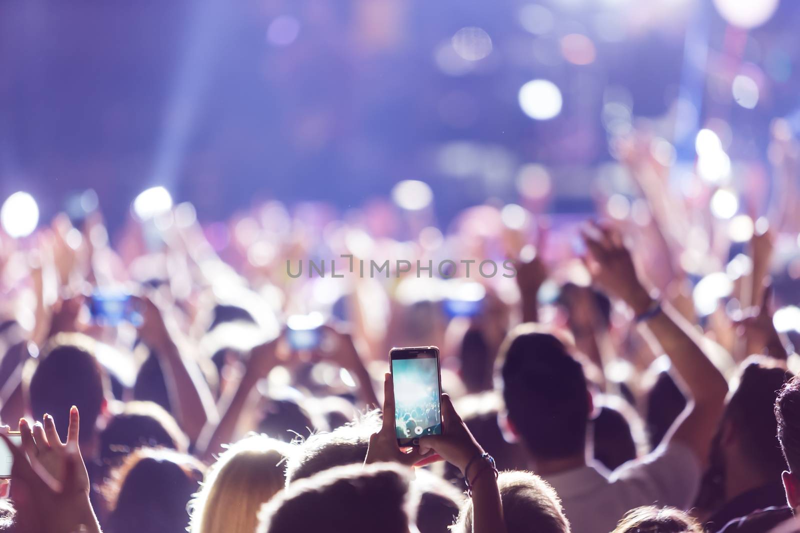 Thessaloniki, Greece - September 11, 2016: Hand with a smartphone records live music festival, Taking photo of concert stage, live concert, music festival, happy youth, luxury party, landscape exterior.