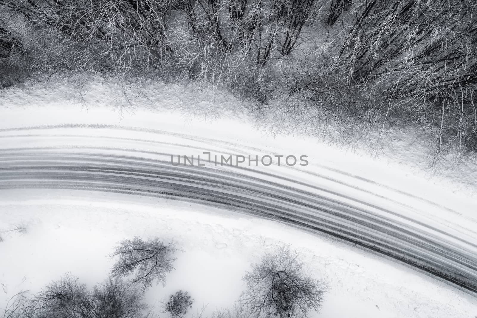 Aerial view of snowy forest with a road in the area of Naoussa in northern Greece.  Captured from above with a drone.