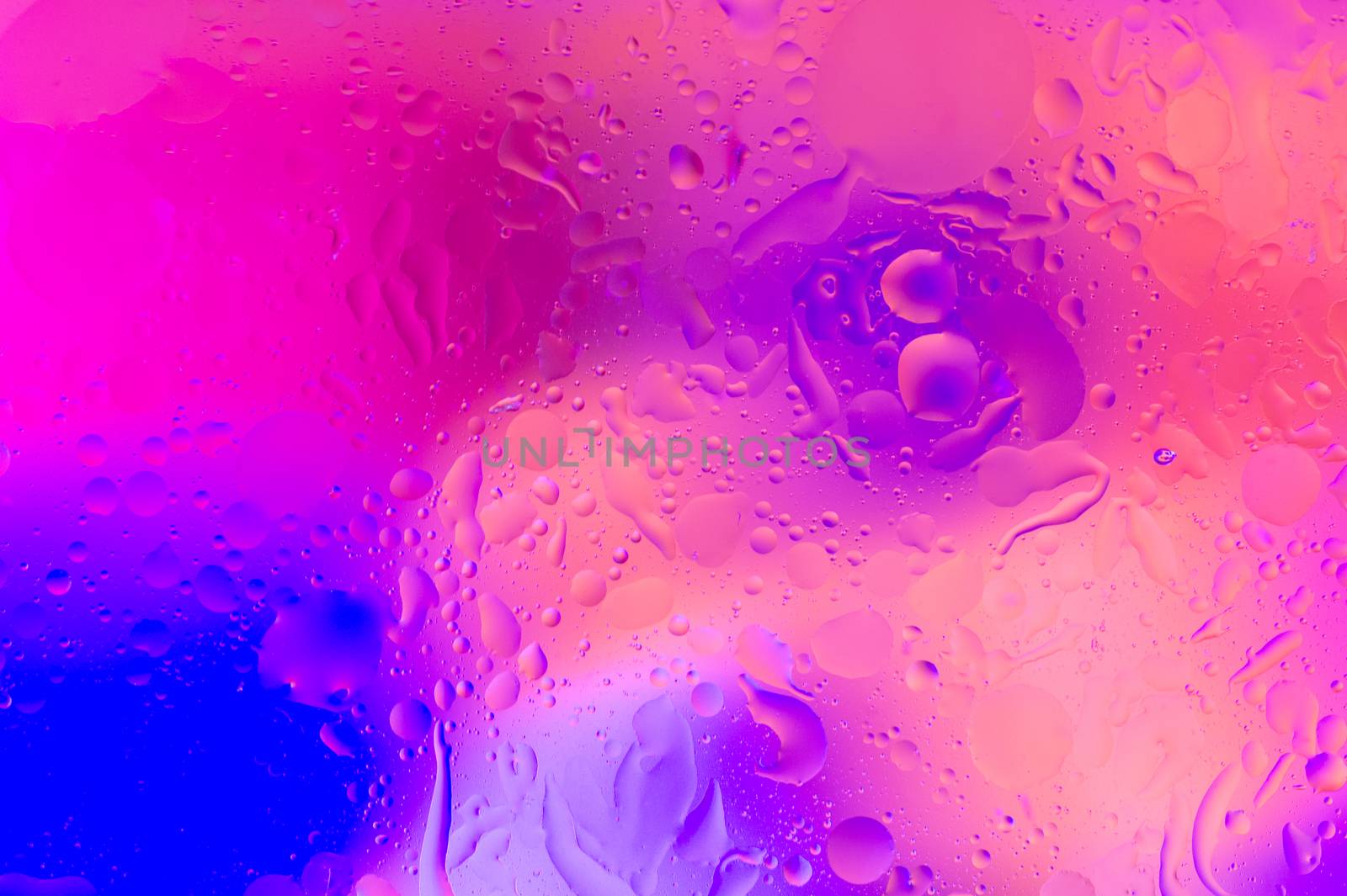 The hue purple abstract composition of oil drops in water with soft focus effect.