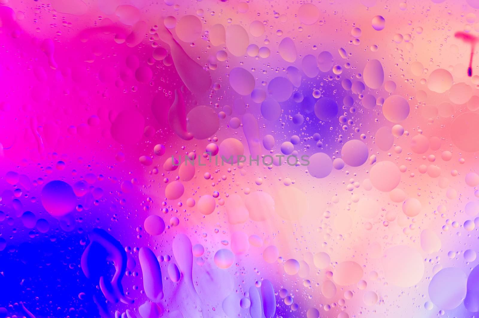 The purple abstract composition with oil drops in water with soft focus effect.