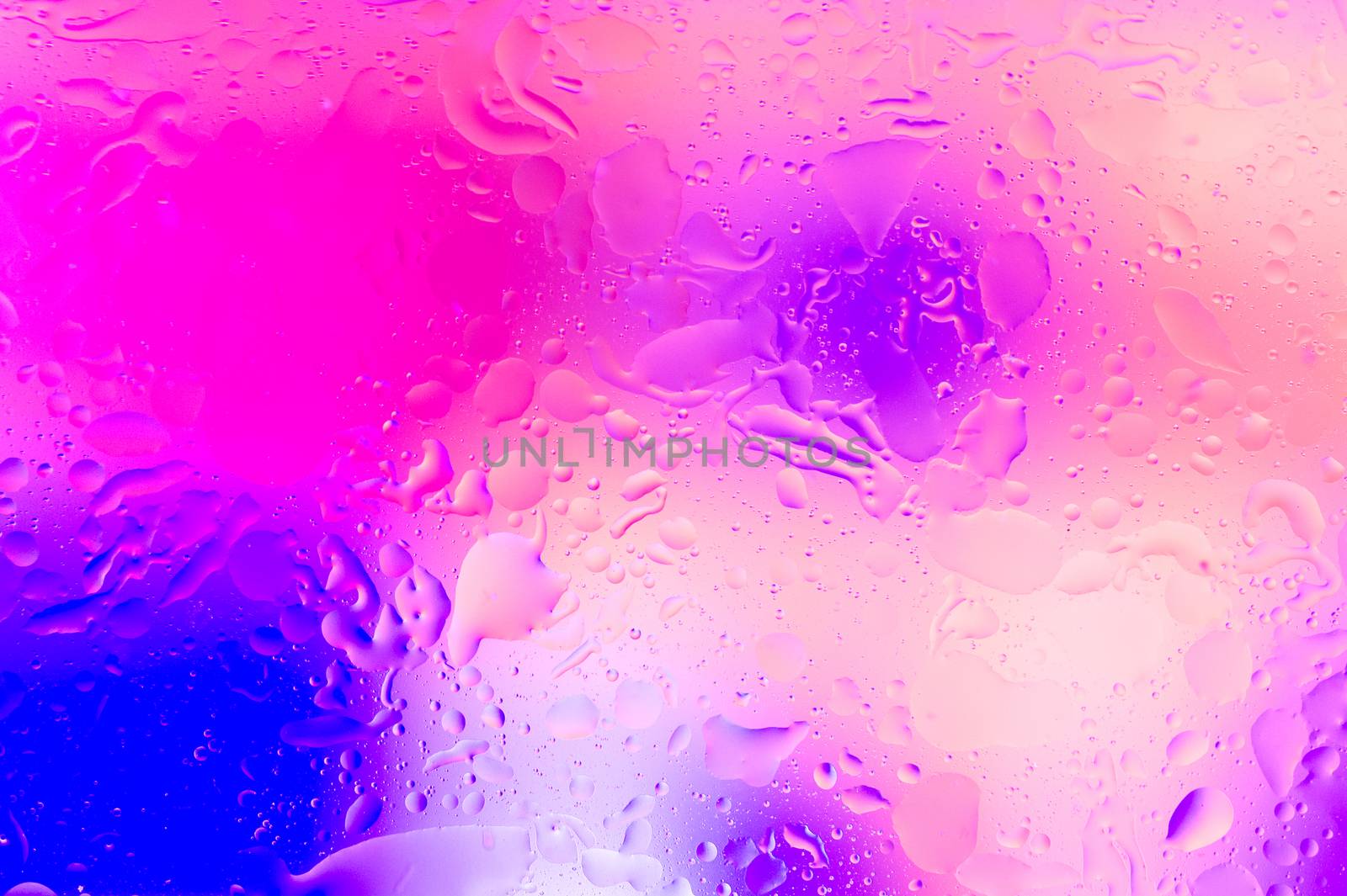 The hue purple abstract composition of oil drops in water with soft focus effect.