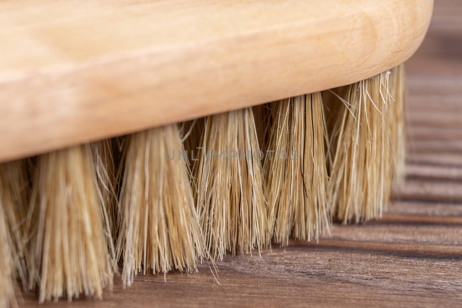 Vintage shoe brush with wooden handle on wooden background. Close up view with small depth of field.