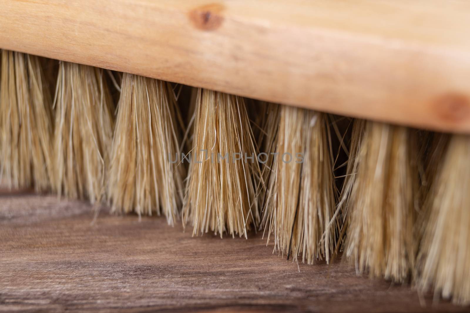 Vintage shoe brush with wooden handle on wooden background. Close up view with small depth of field.