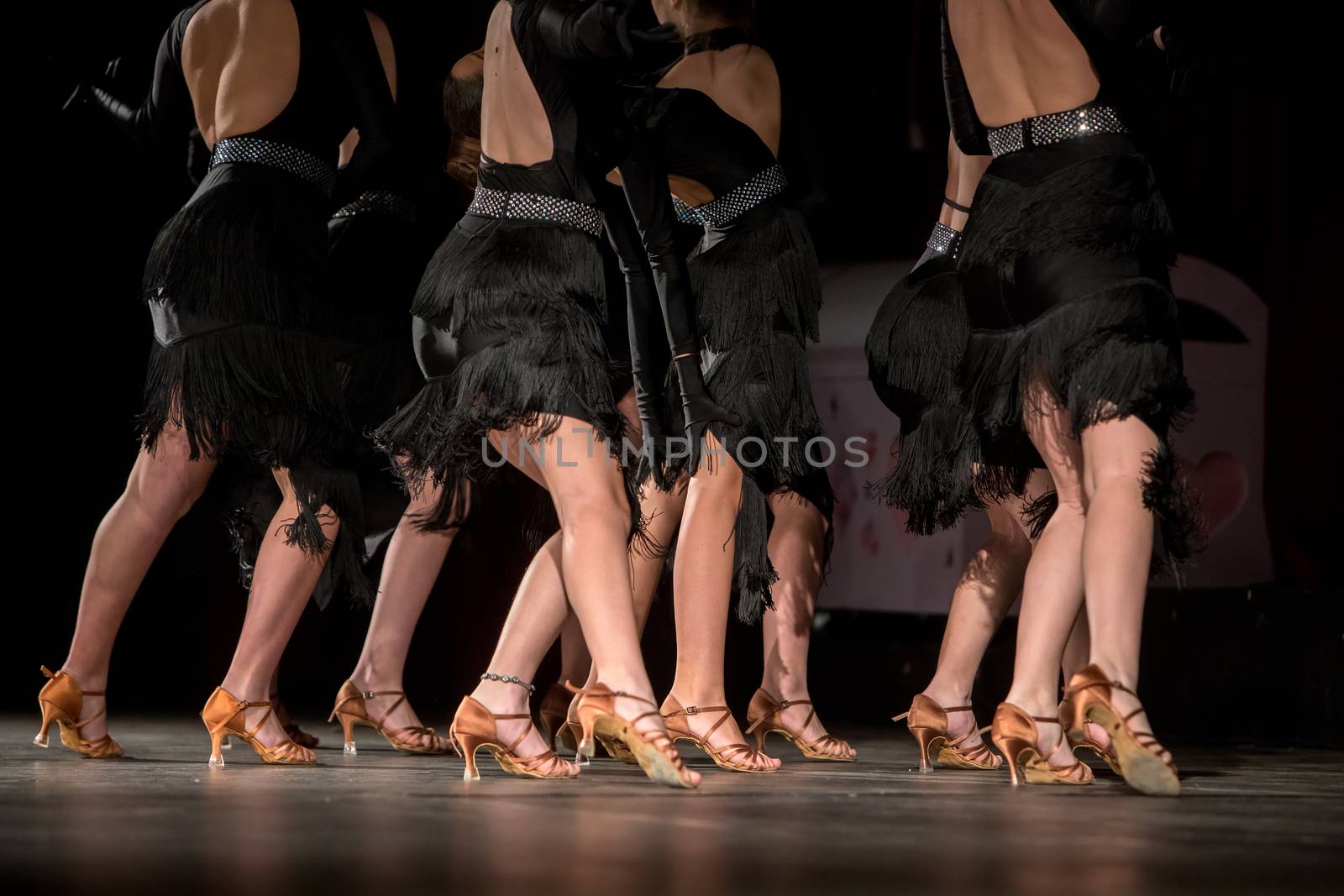 Legs of young dancers on the dance floor 