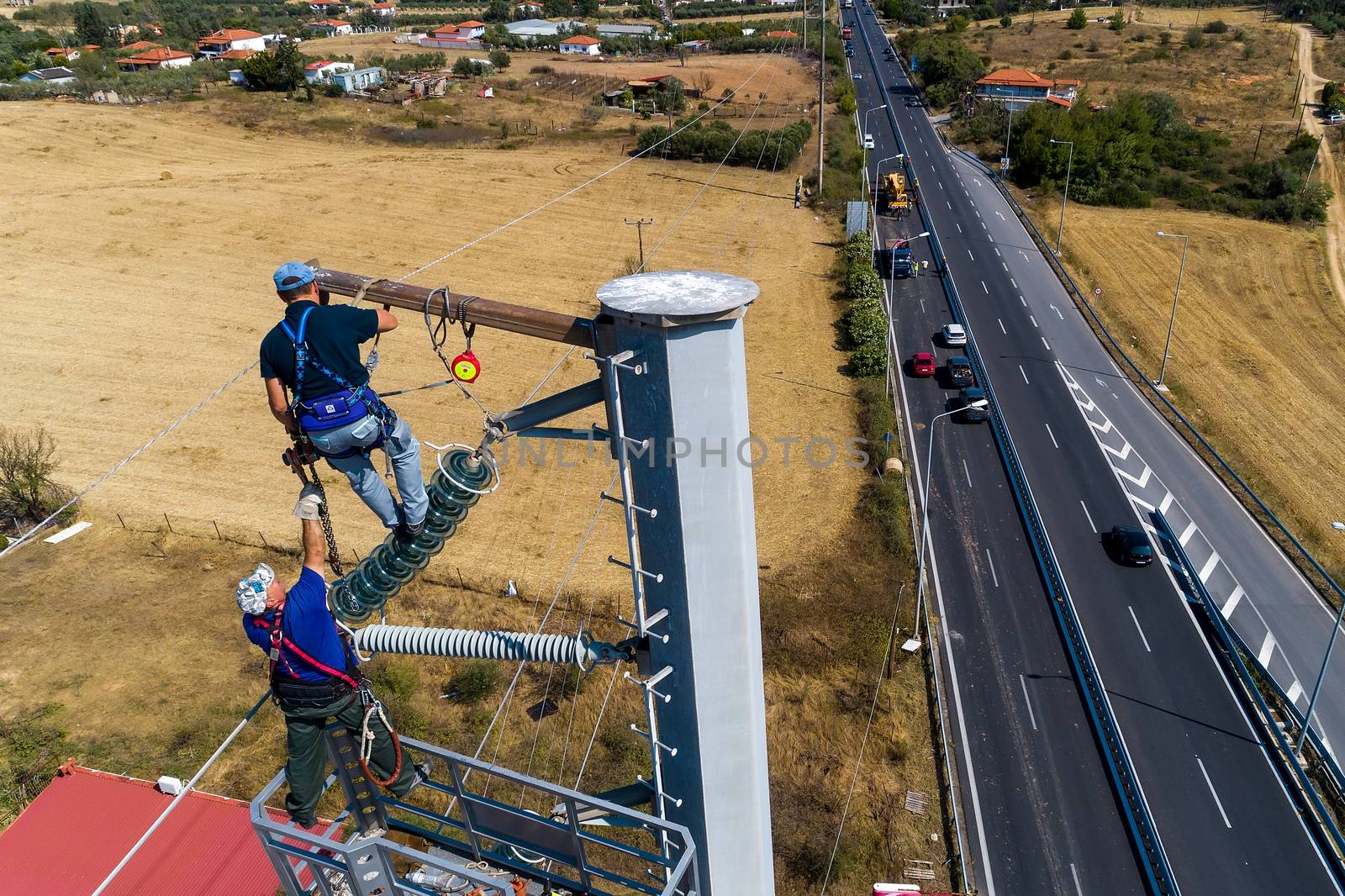 Chalkidiki, Greece - July 12, 2019: Electricians are climbing on electric poles to install and repair power lines after the fierce storm that struck the area