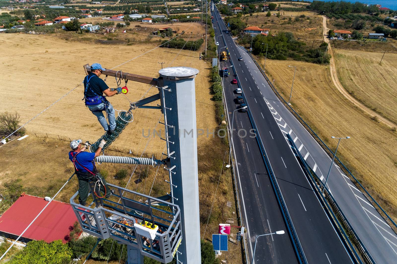 Chalkidiki, Greece - July 12, 2019: Electricians are climbing on electric poles to install and repair power lines after the fierce storm that struck the area