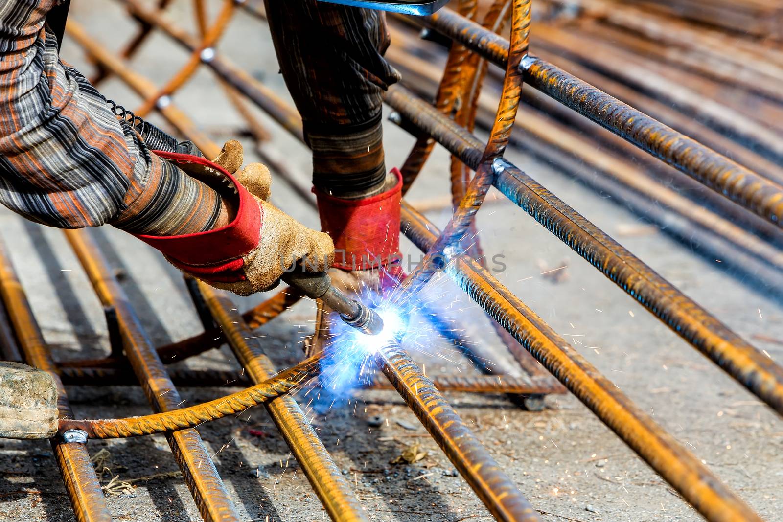 Close up of the hands welder worker with electrode by ververidis