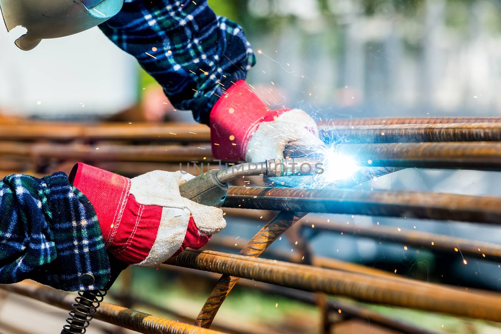 Close up of the hands welder worker with electrode by ververidis