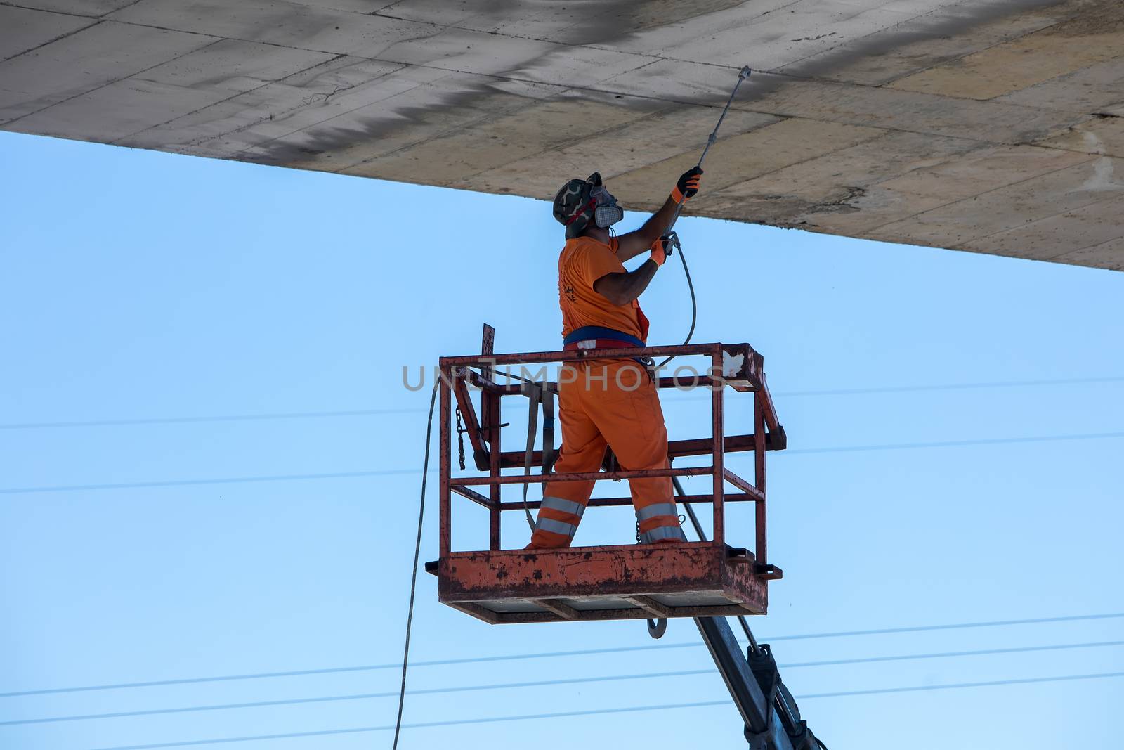 worker on a lifting machine works on the construction by ververidis