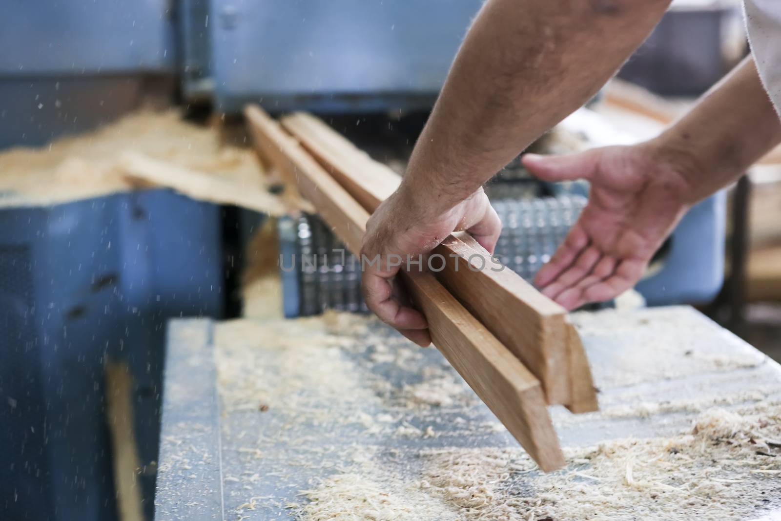 Thessaloniki, Greece, July 8, 2015: Craftsmen cut a piece of wood at a woodworking factory in Greece. Wood and furniture production plant, industrial factory with tools and objects.