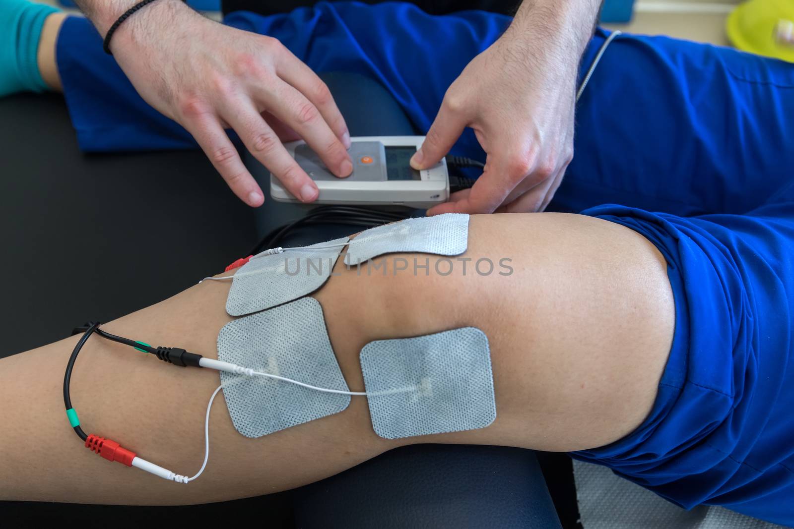 electronic therapy on knee used to treat pain. selective focus