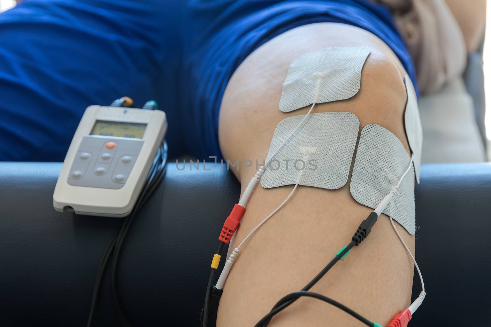 electronic therapy on knee used to treat pain. selective focus