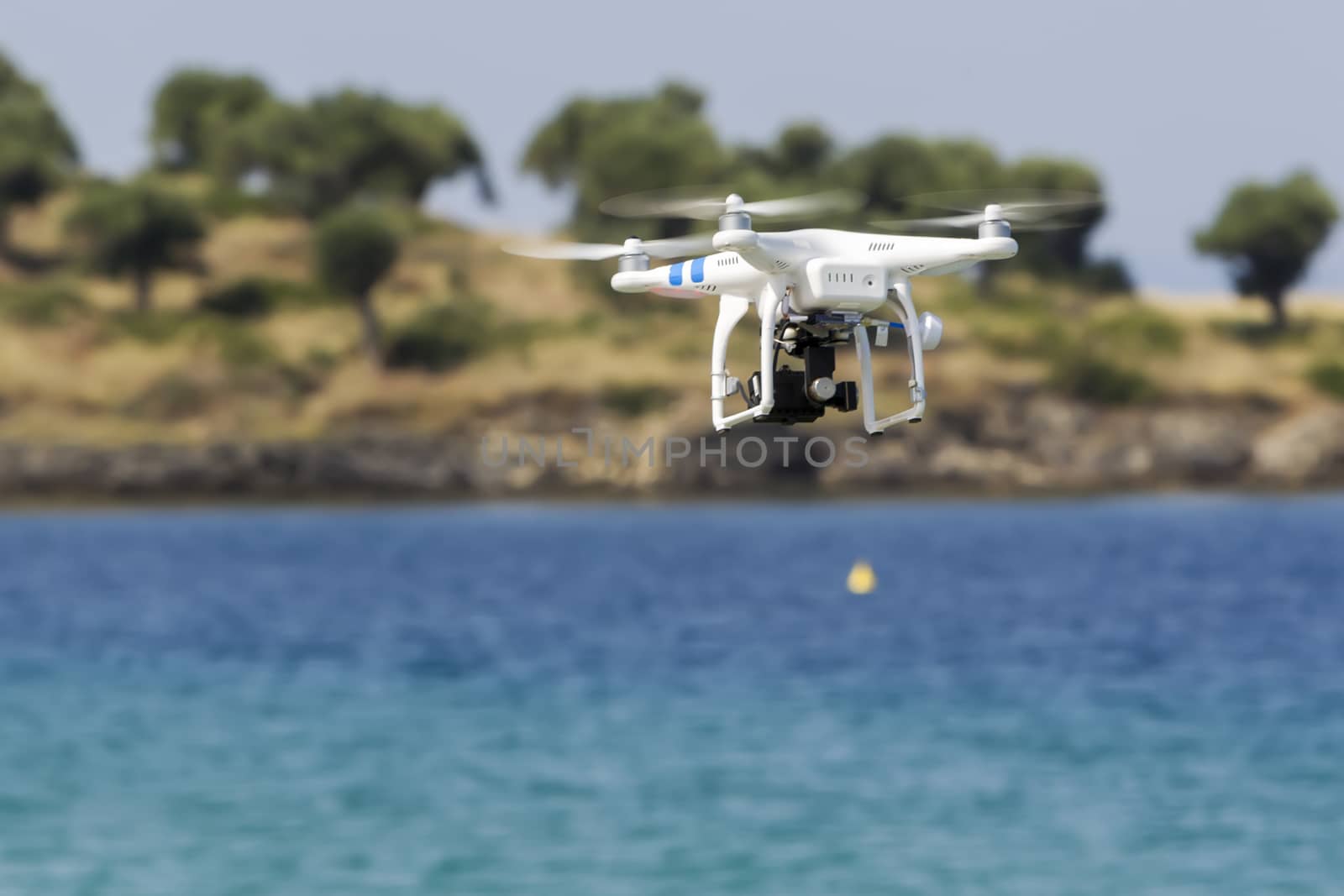 MARMARAS, GREECE- JULY 29, 2014: DJI Phantom drone in flight with a mounted GoPro Hero3+ Black Edition digital camera in Marmaras, Greece. DJI Industries produces unmanned aircraft for surveillance
