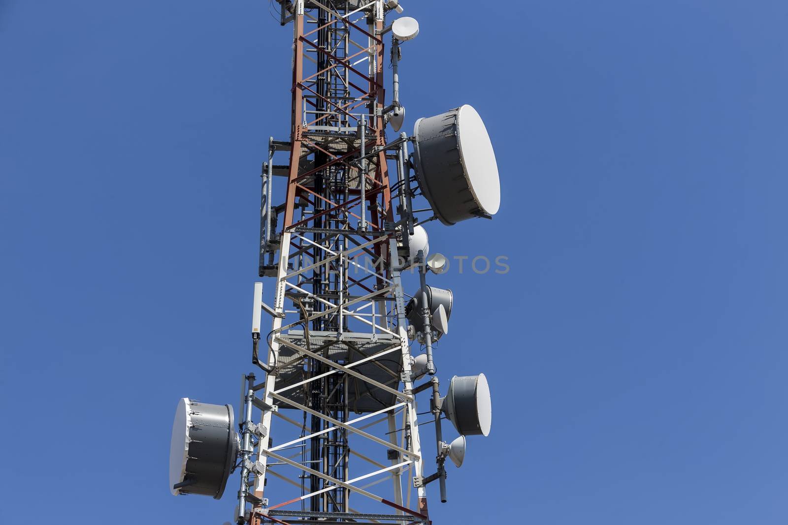 communications tower with antennas against blue sky