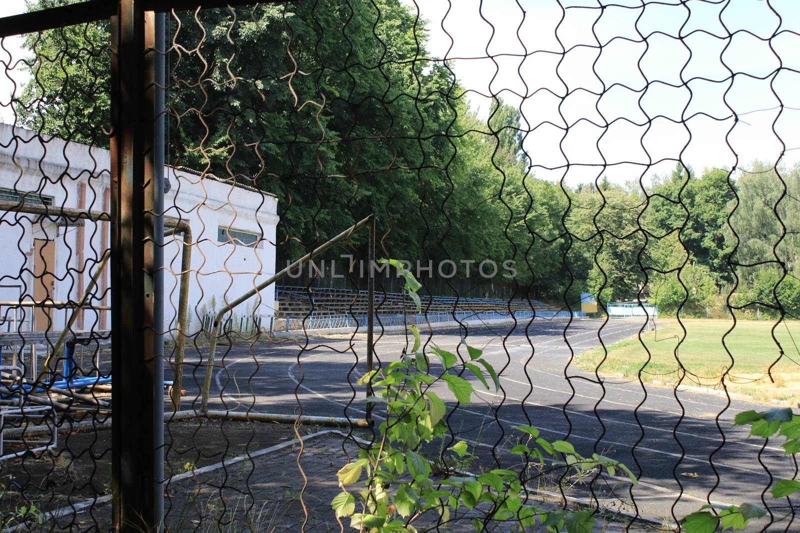 Treadmill in the open-air stadium through an iron fence