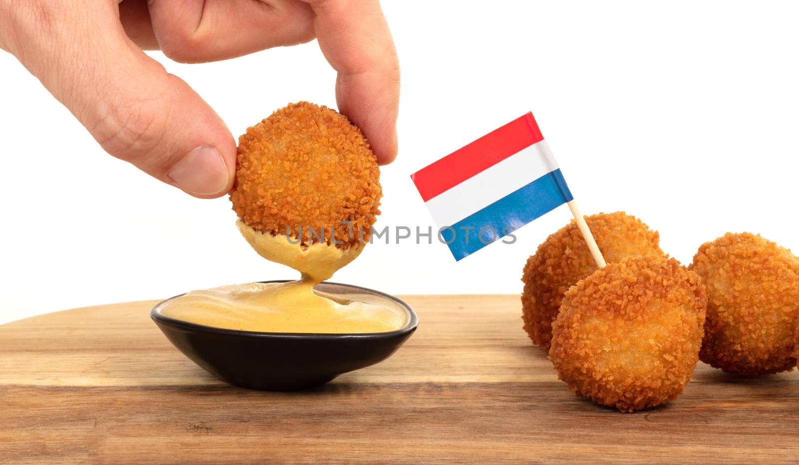 Dutch traditional snack bitterbal in a hand by michaklootwijk