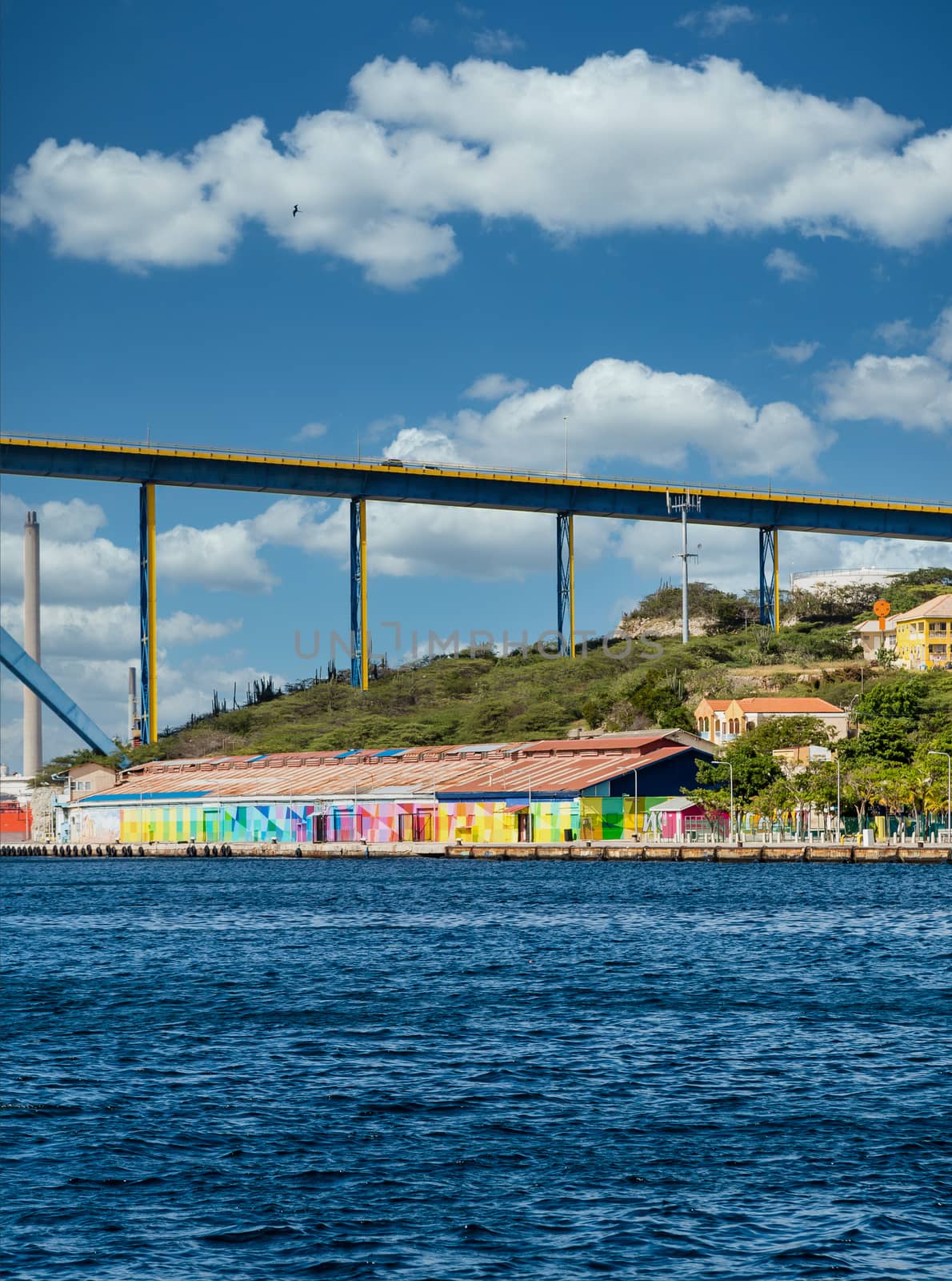 Colorful buildings in Curacao under the blue sky bridge