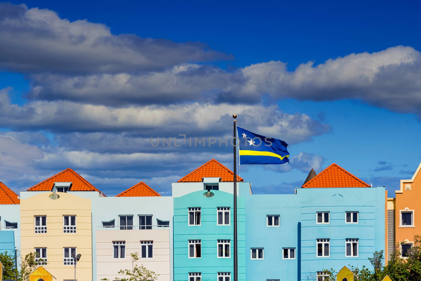 Curacao Flag by colorful buildings under nice skies