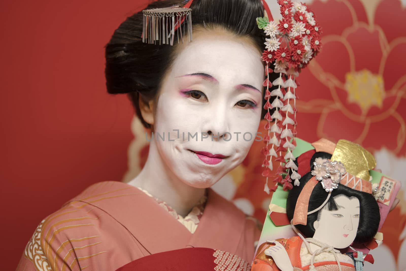 Geisha holding an hagoita doll. by kuremo