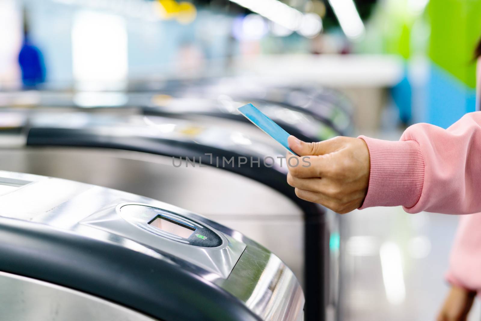 Woman hand scanning train ticket to subway entrance gate. Transp by psodaz