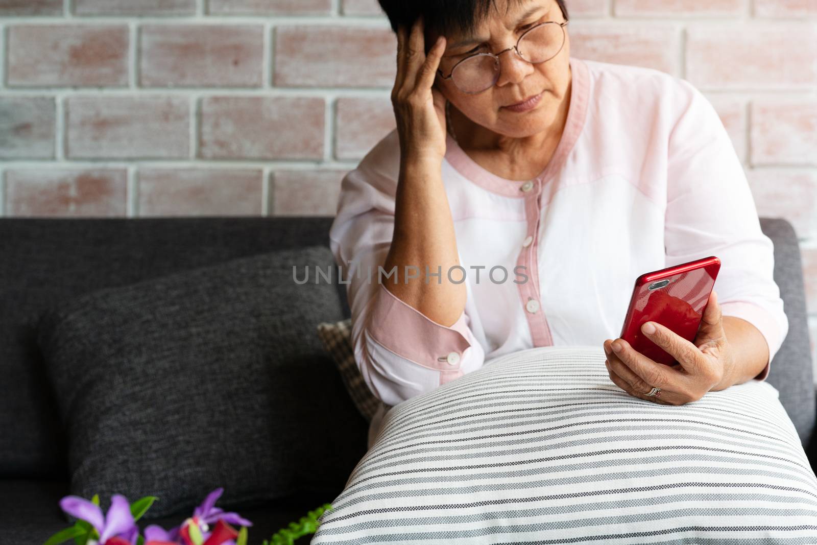 Old woman headache while using smartphone, healthcare concept