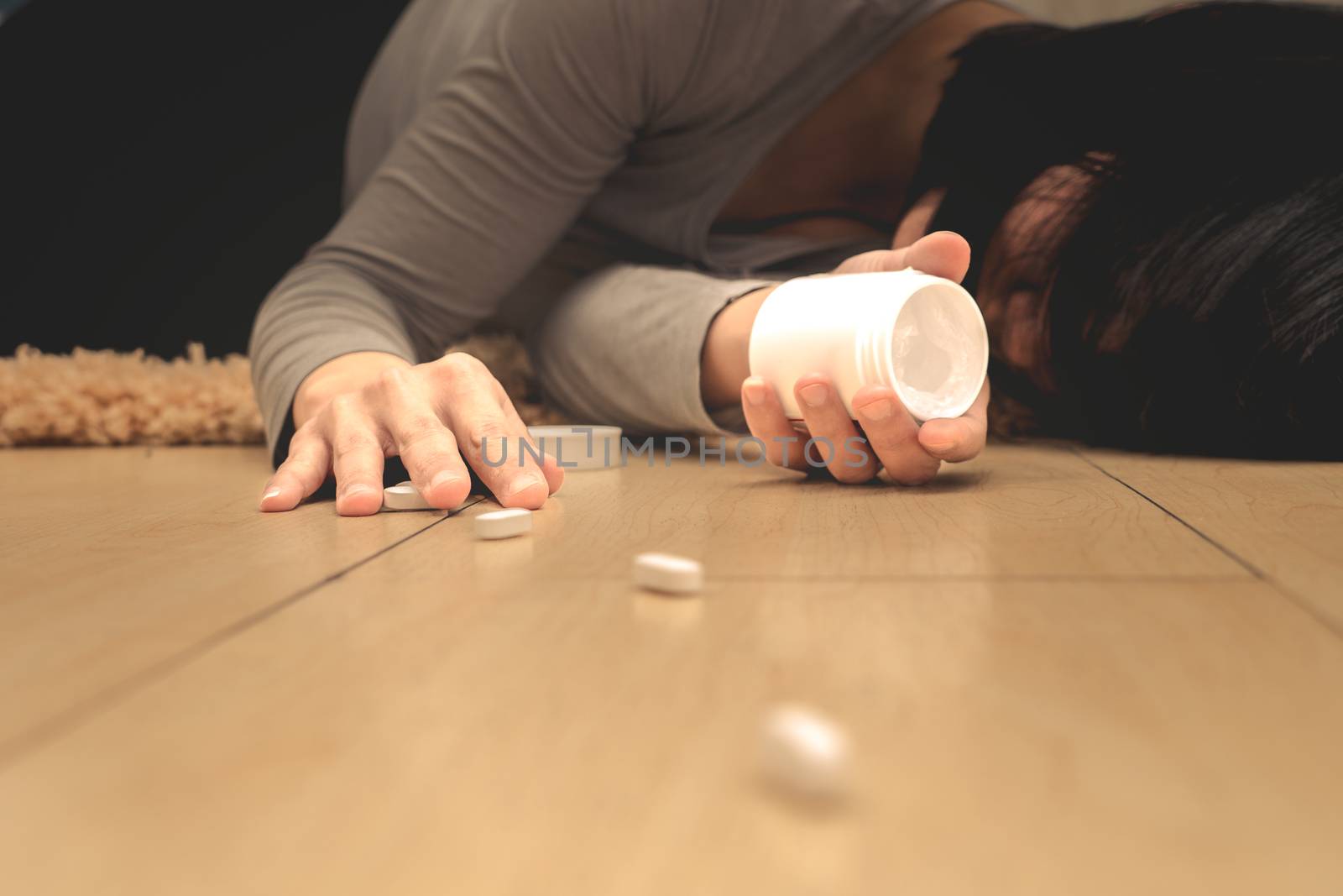 women lay down after taking medicine overdose with open pills bottle. Concept of overdose and suicide.