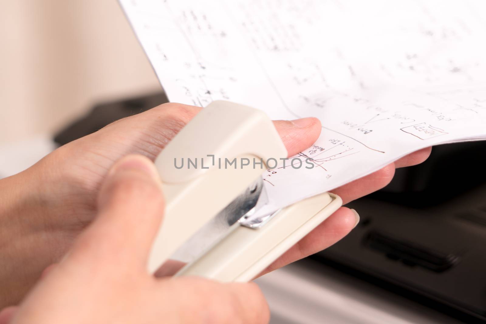 focus on the women hand stapling the hand writing paper, working and office concept