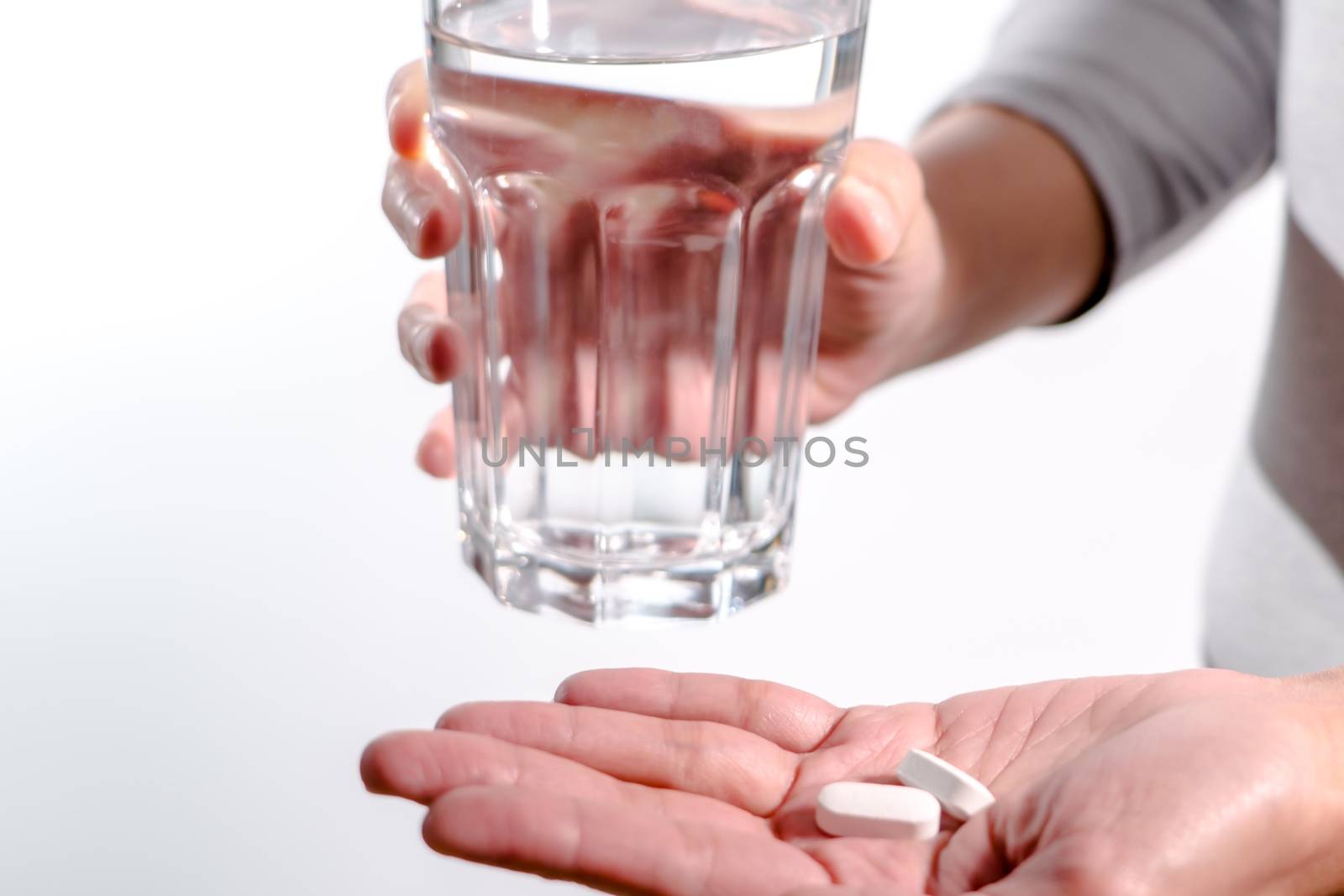 focus on the women hand holding the medicine with a glass of water, medicine recovery concept