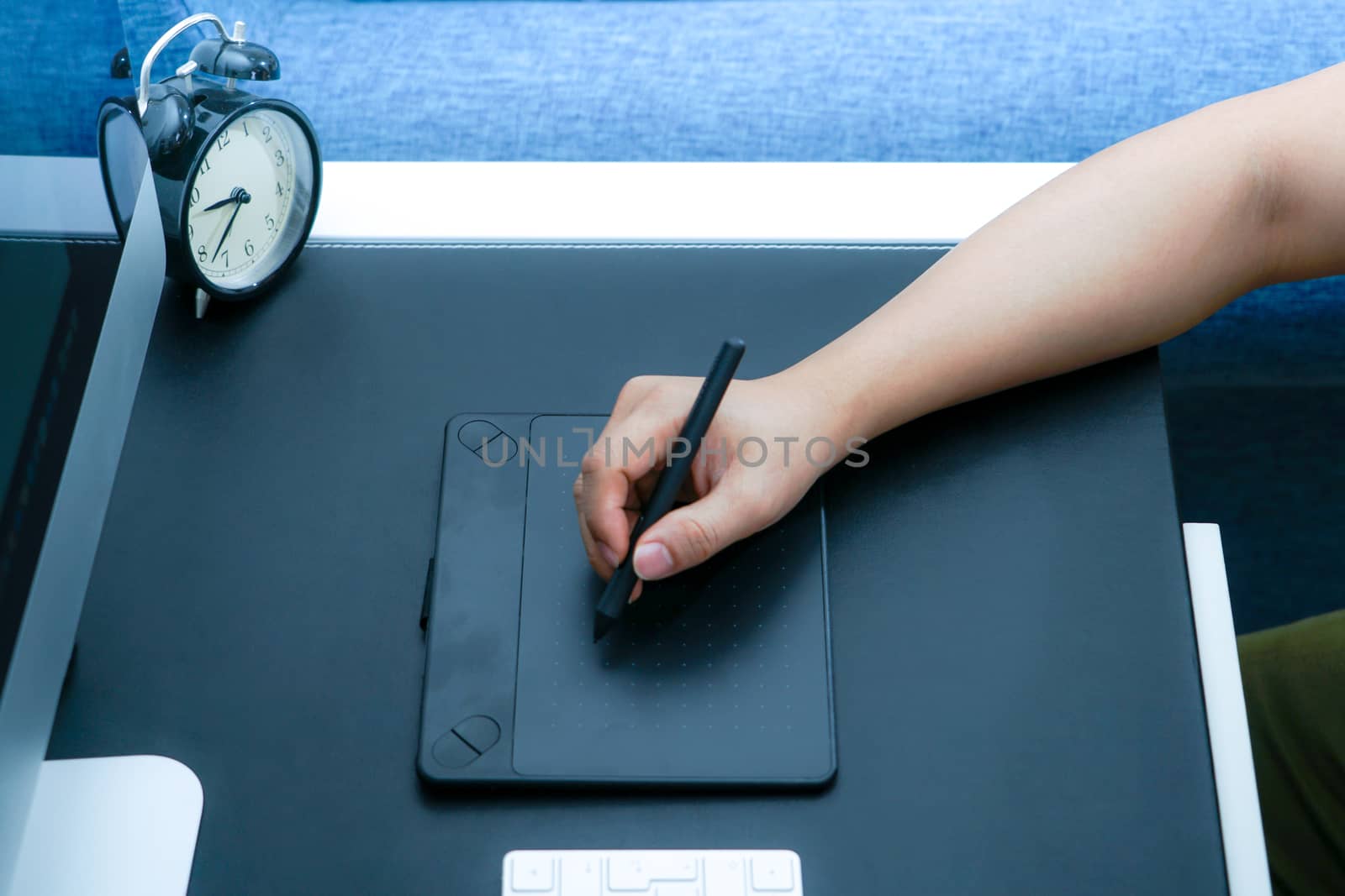 Focus on the busy graphic designer working on computer by digital pen mouse
