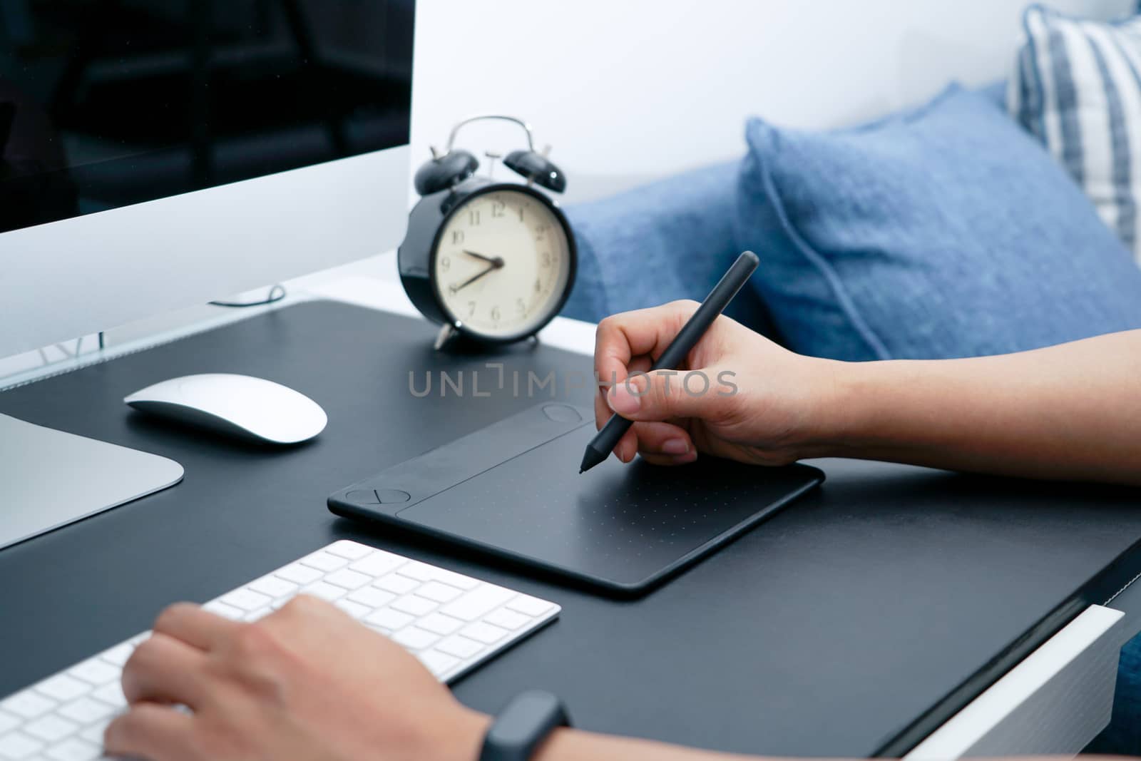 Focus on the busy graphic designer working on computer by digital pen mouse