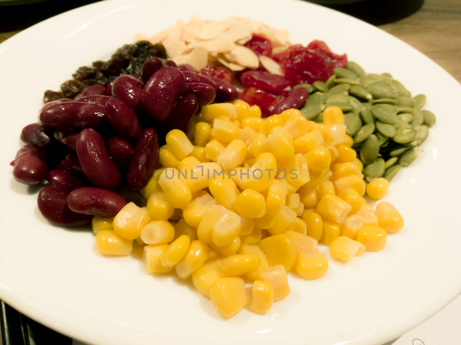 Pile of the steam yellow corn, red bean, sunflower seed, almond, raisin and sweet dried jujube, salad and healthy food