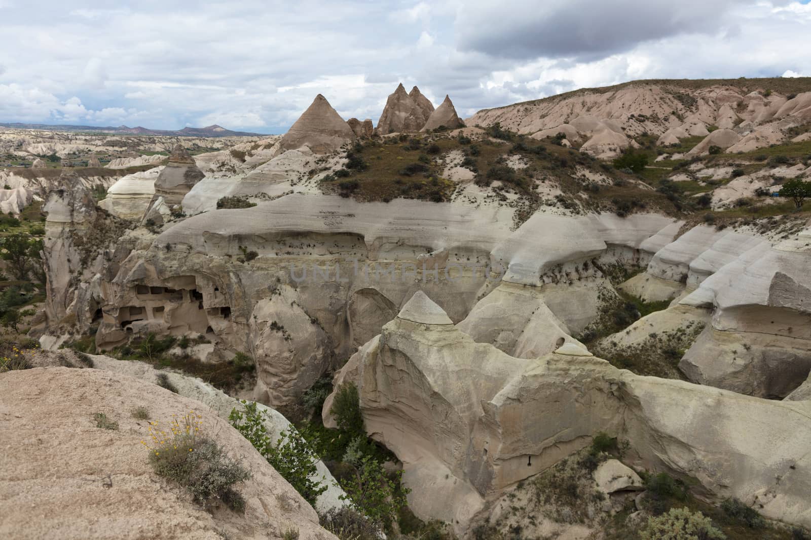 Red and white sandstone cliffs, ancient caves in a mountain landscape between valleys in Cappadocia, central Turkey