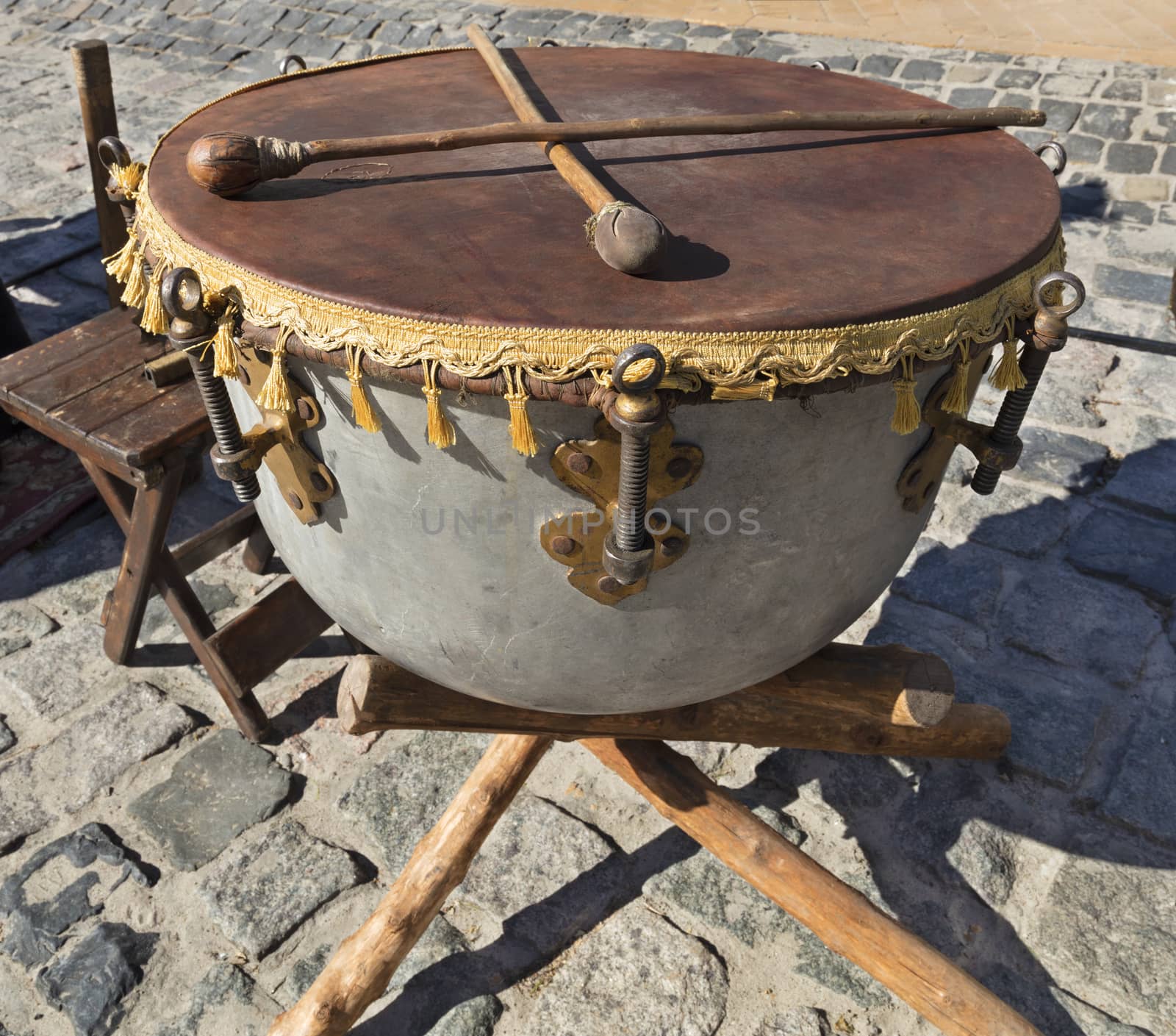 Old Ukrainian ethnic Cossack drum close-up on the background of the old cobbles road