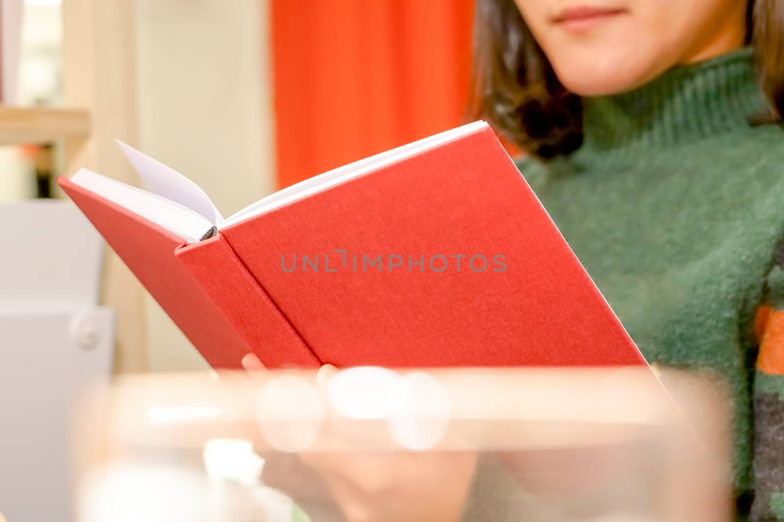 the open red book is holding/reading on women hand at home