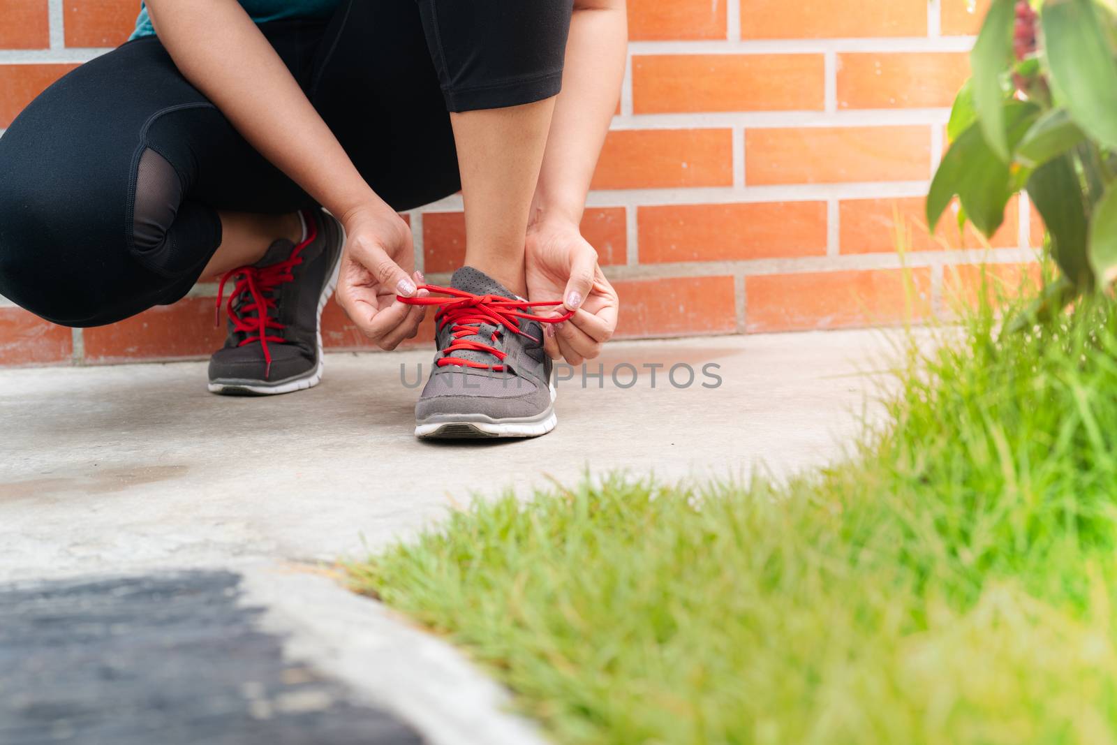 sport woman tying shoelace before running, outdoor activities by psodaz