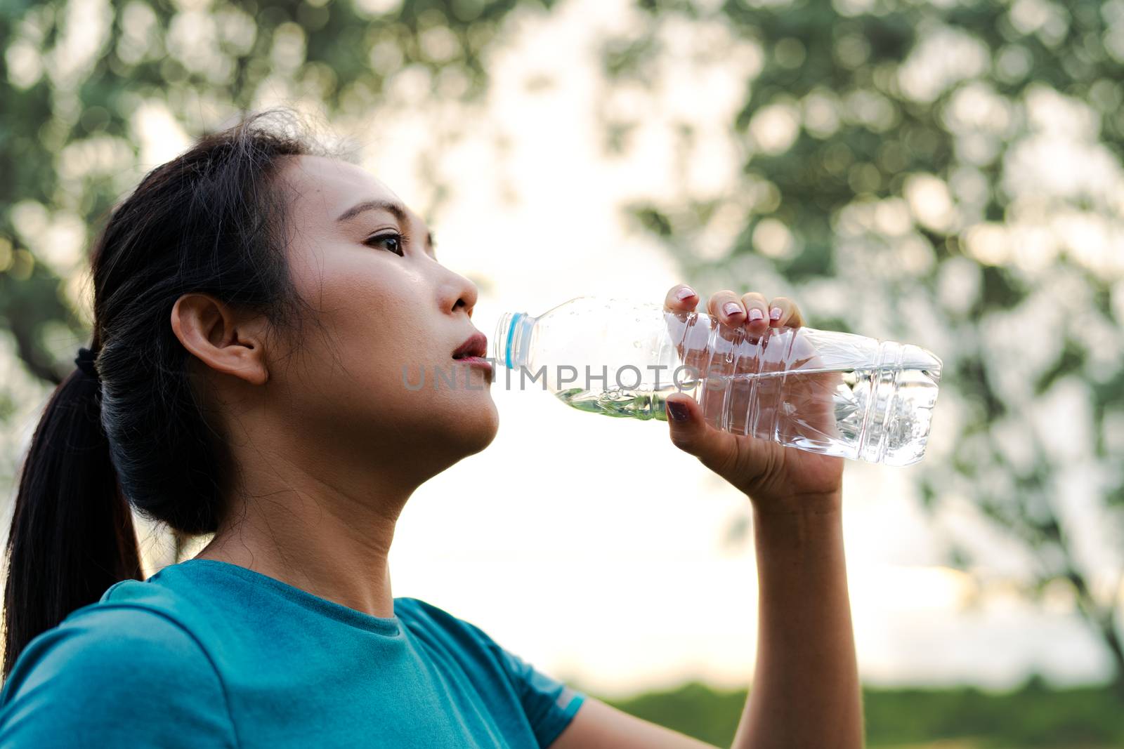 Fitness Asia Woman Drinking Water after Running by psodaz
