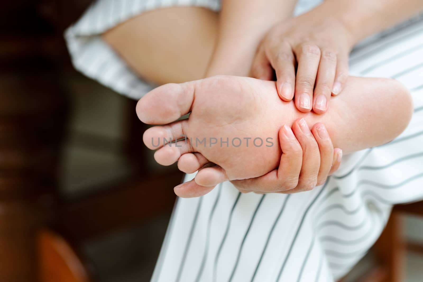 Woman massaging her painful barefoot, healthcare and medical con by psodaz