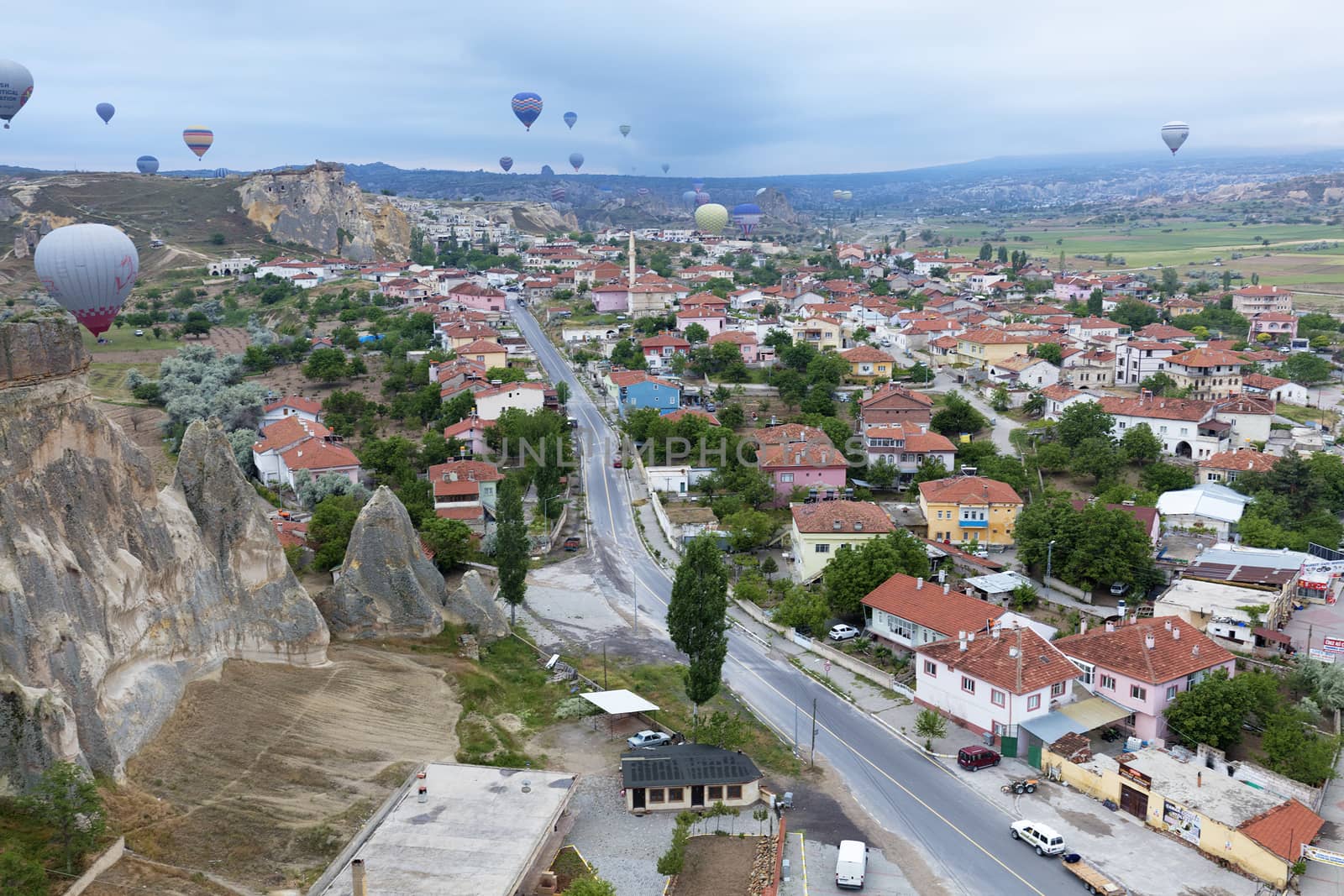 View of dozens of balloons flying over the valleys of Cappadocia at dawn in central Turkey.