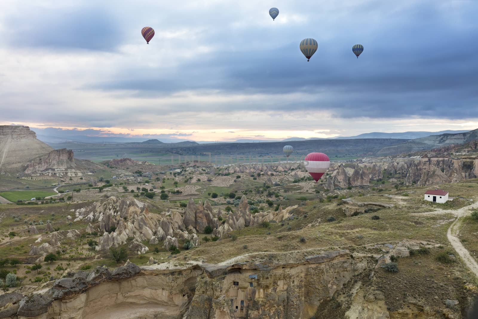 A view of several balloons flying over the valleys of Cappadocia at dawn in central Turkey.