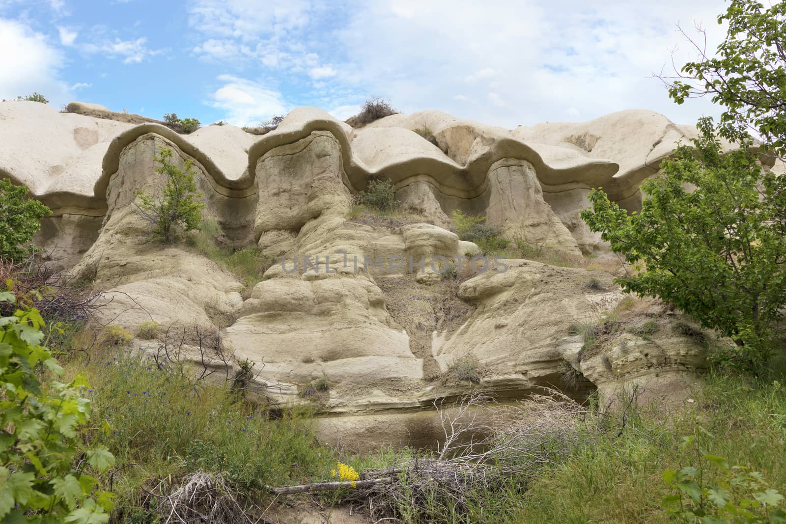 Red and white sandstone cliffs, ancient caves in a mountain landscape between valleys in Cappadocia, central Turkey