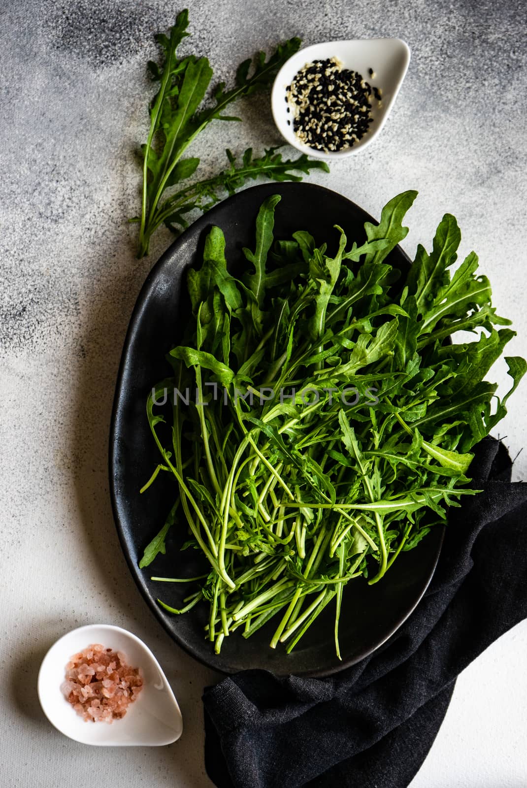 Healthy food concept with fresh organic arugula herb leaves on stone background with copy space