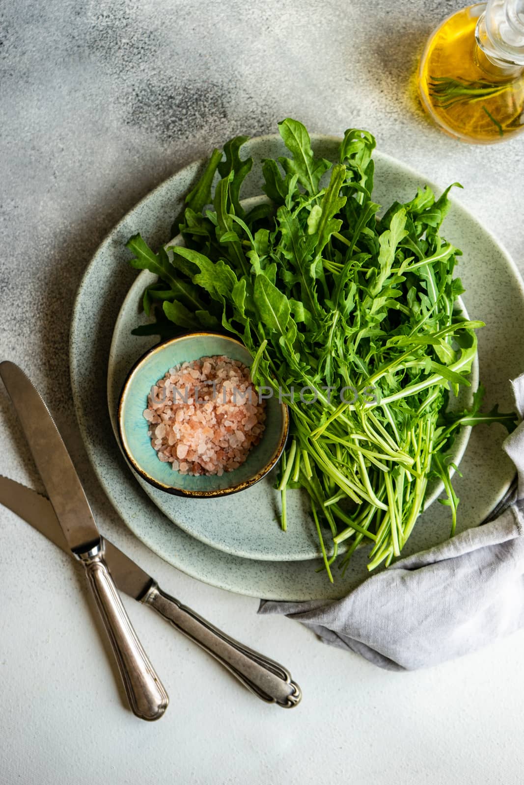 Healthy food concept with fresh organic arugula herb leaves on stone background with copy space