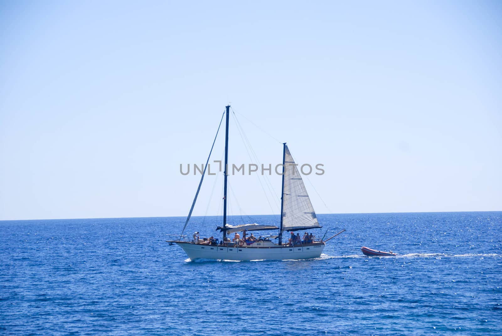 Sailboat on the sea with inflatable boat by cosca